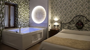 Una habitación con una lámpara circular grande, una bañera y una cama con papel tapiz floral.