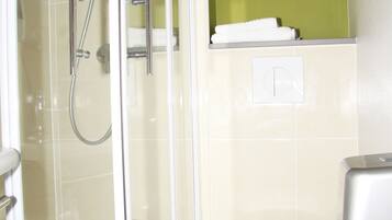 Ein Badezimmer mit Duschkabine, Toilette und Handtuchhalter.