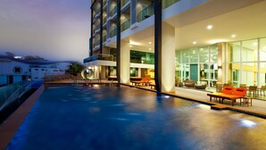 A modern hotel with a rooftop infinity pool, outdoor seating, and large windows. - Balihai Bay (Pattaya)