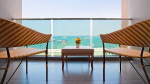 A balcony with two wicker chairs and a small table, overlooking a marina with boats. - Balihai Bay (Pattaya)