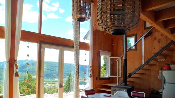 A wooden cabin with a dining area, a kitchen, and a staircase. - Un Vistón Modern Mountain Home (San Martín de los Andes)