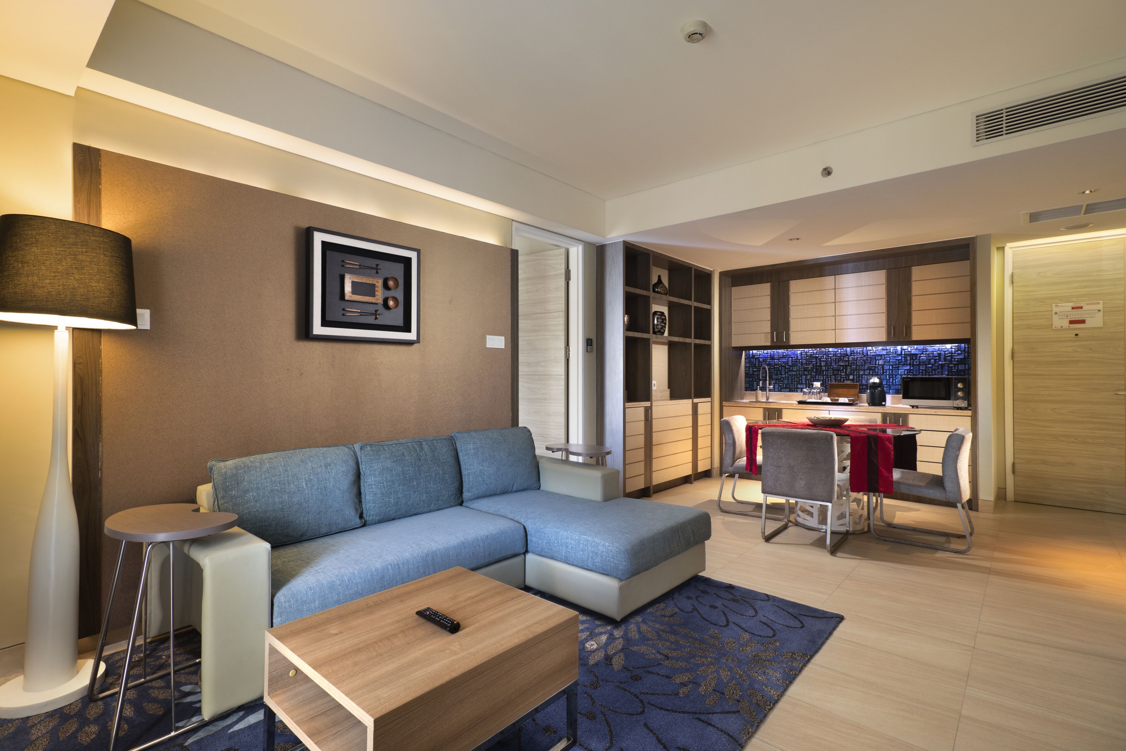 Una sala de estar moderna con un sofá modular, una mesita y un comedor con sillas.