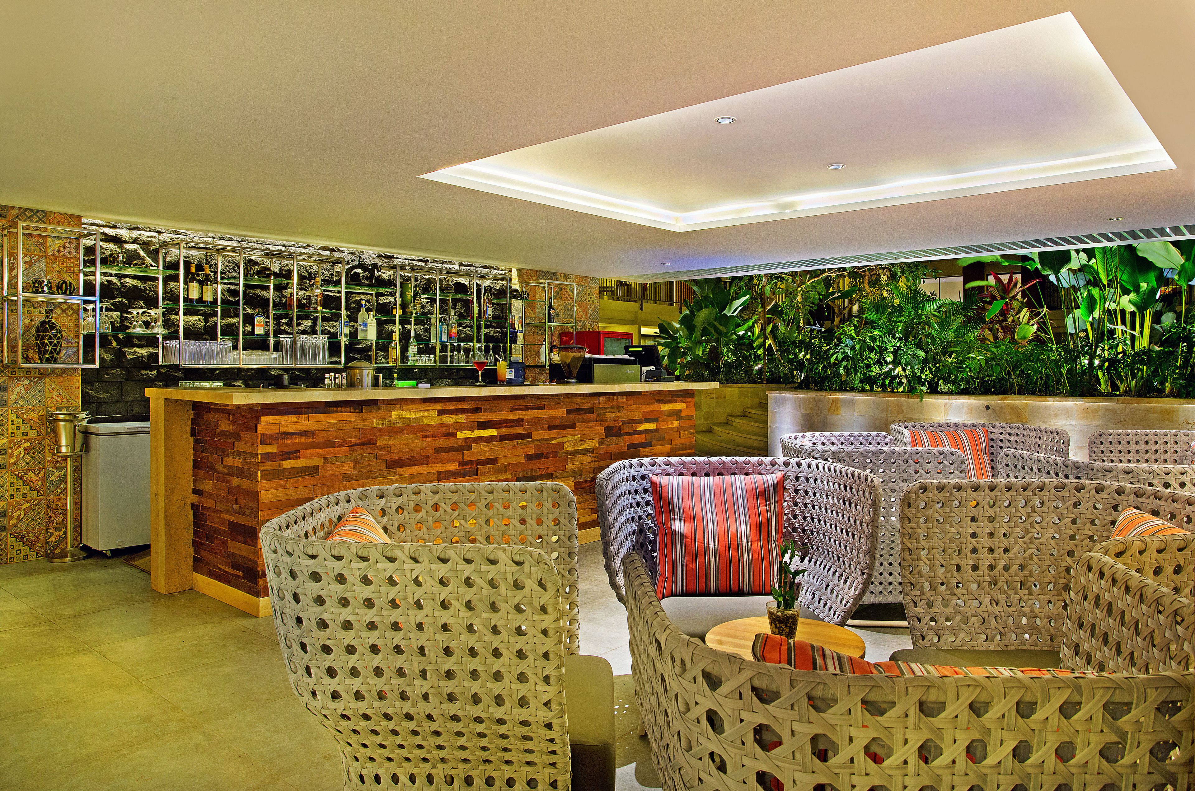 Un espace bar moderne avec un comptoir en bois et des meubles en osier.