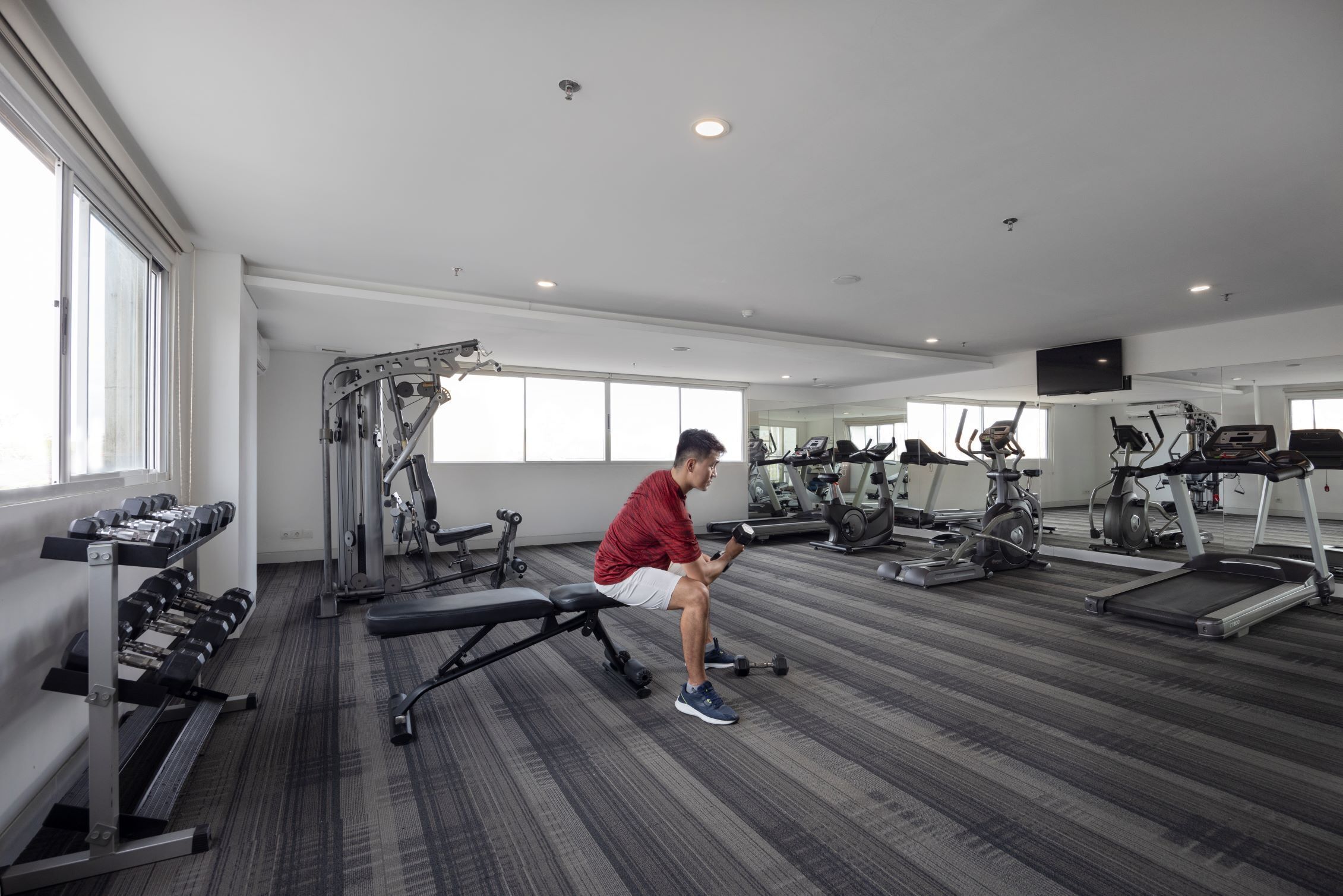 A gym with various exercise equipment, including treadmills and weight machines.