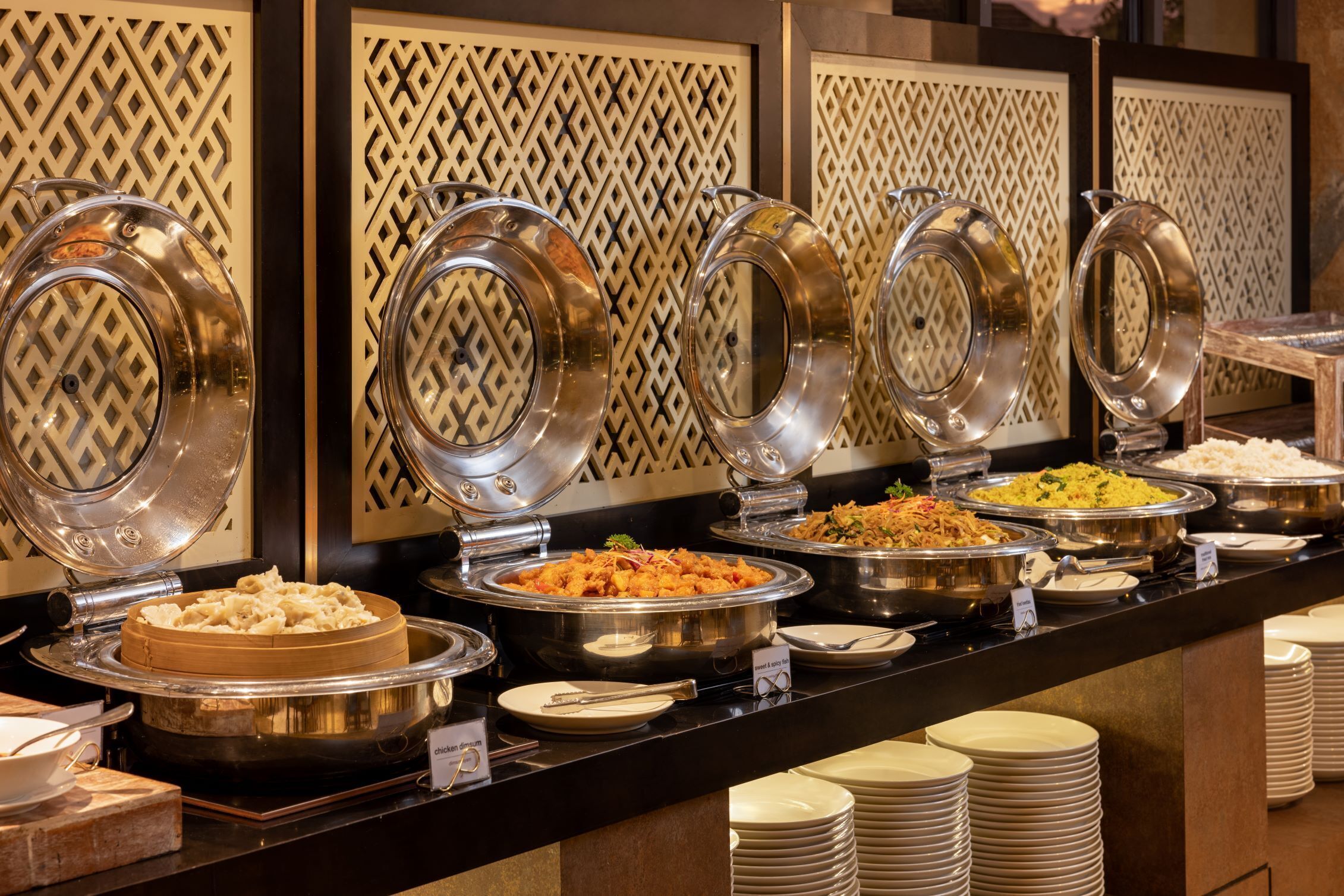 A buffet with multiple food stations, including a variety of dishes in metal serving dishes.