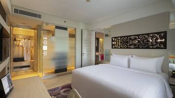 A hotel room with a large bed, a wardrobe, a mirror, and a wall art piece.