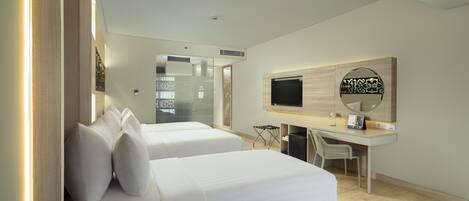 A modern hotel room with two beds, a desk, a TV, and a mirror.