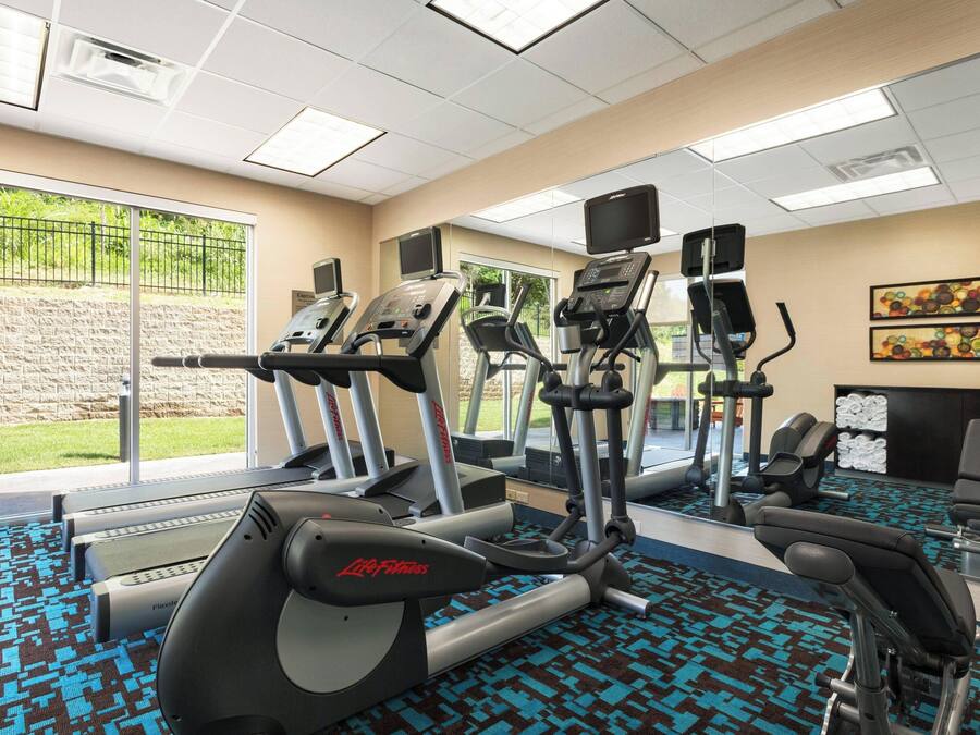 A gym with treadmills, elliptical machines, and a stationary bike.