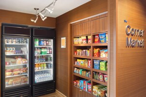Un mercado de barrio con secciones refrigeradas y estantes llenos de aperitivos y bebidas.
