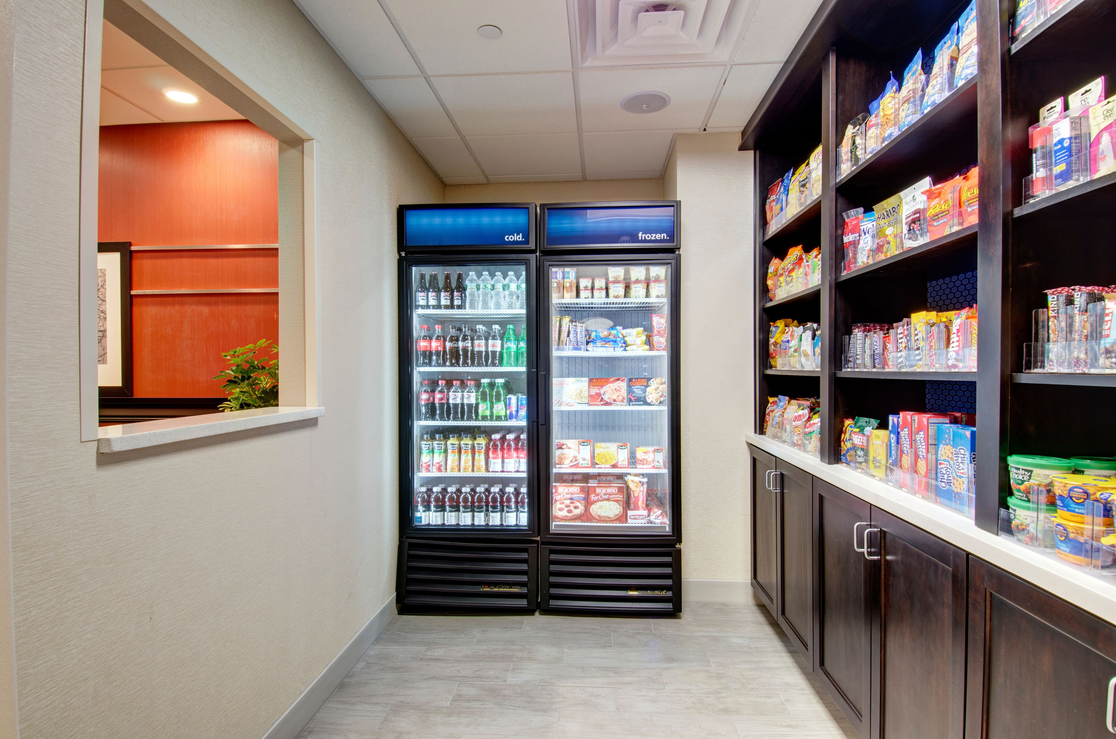 A narrow hallway with two beverage dispensers and a snack shelf.