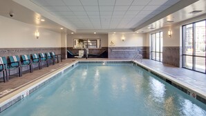 Una piscina interior con elevador para piscina, vestuario y vistas al exterior.