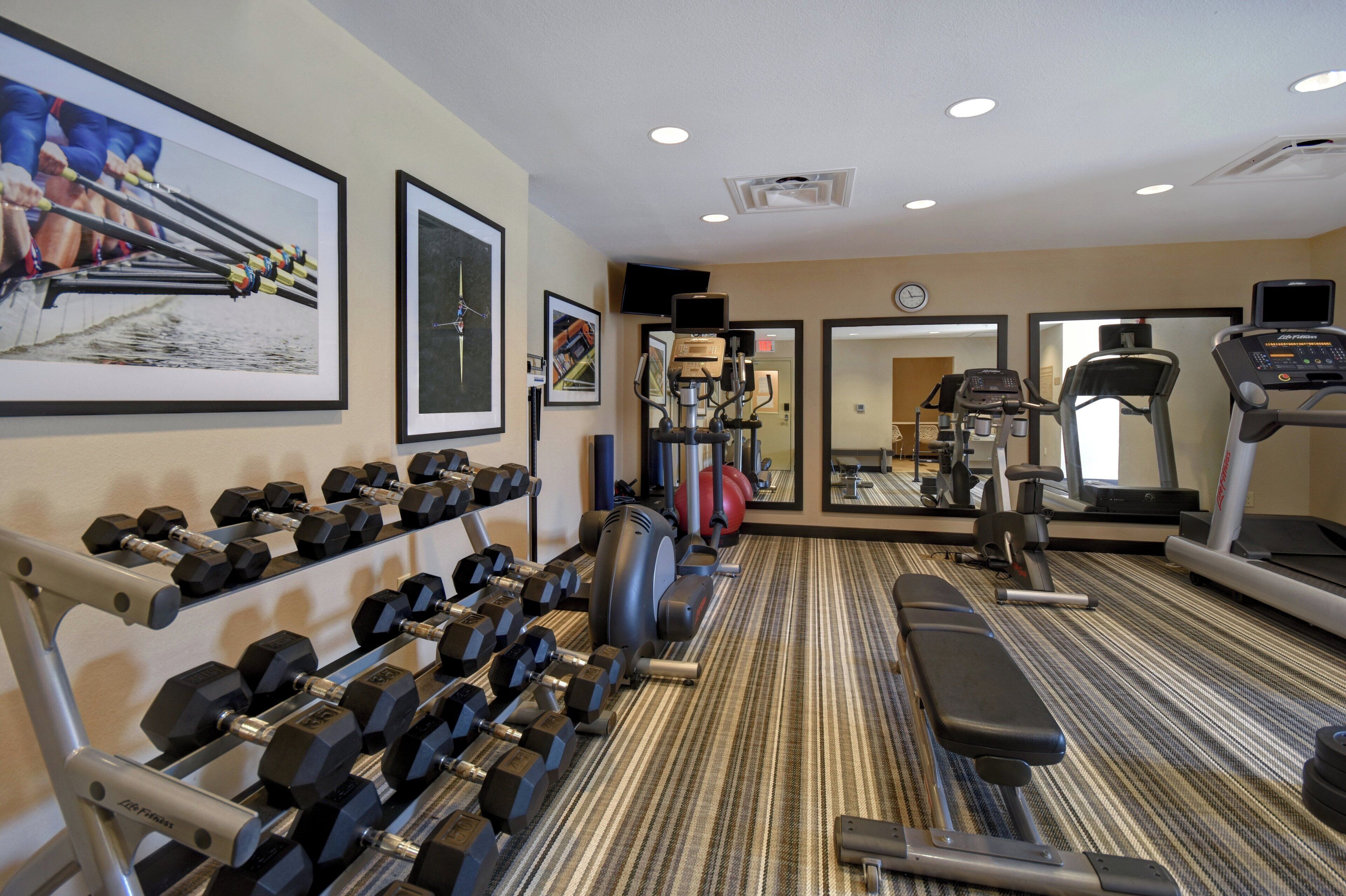A gym with various exercise equipment, including dumbbells, a treadmill, and a stationary bike.