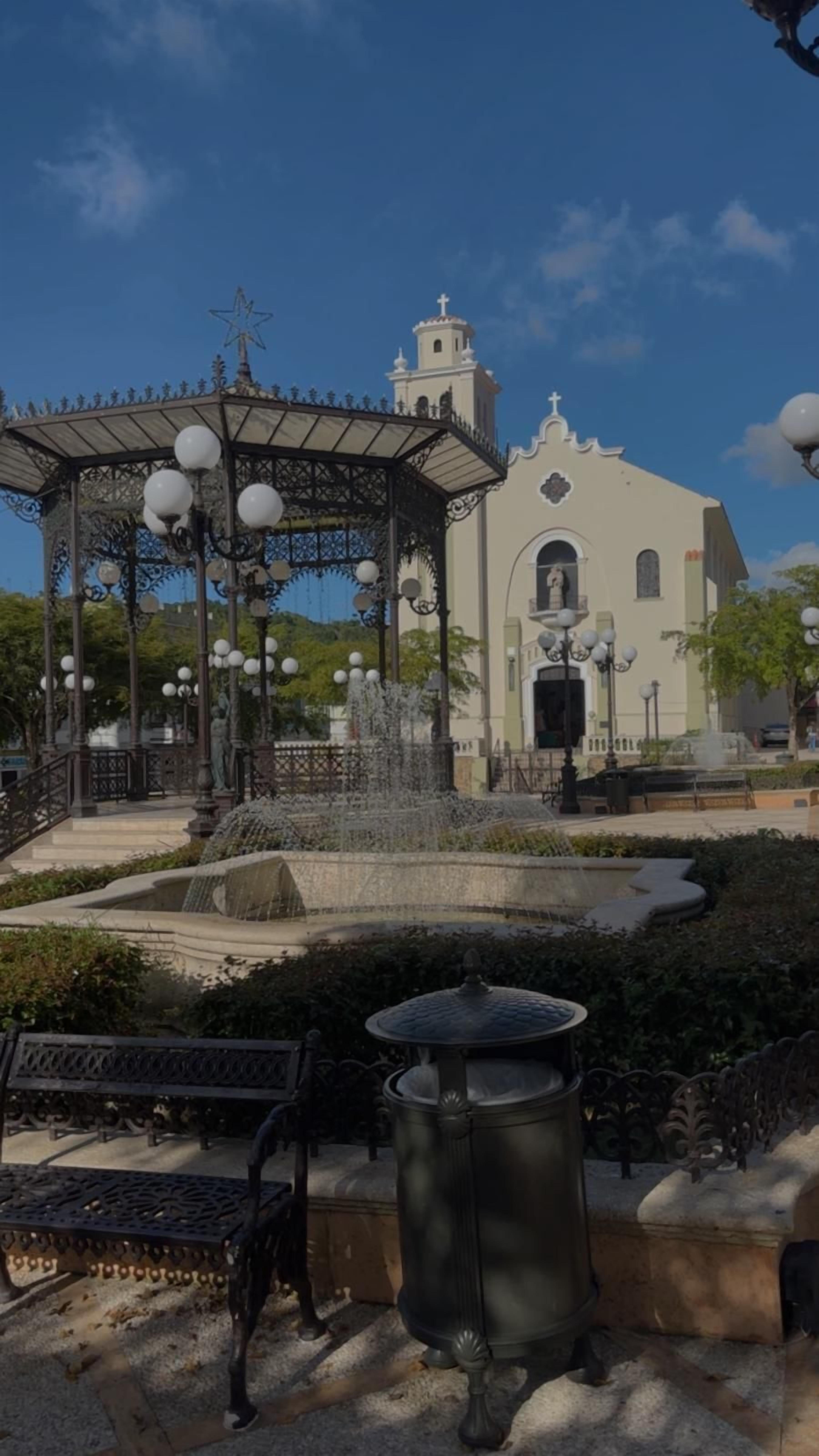 A gazebo with a star on top, a fountain, and a church in the background.