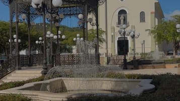 Un pabellón con una estrella en la parte superior, una fuente y una iglesia al fondo.