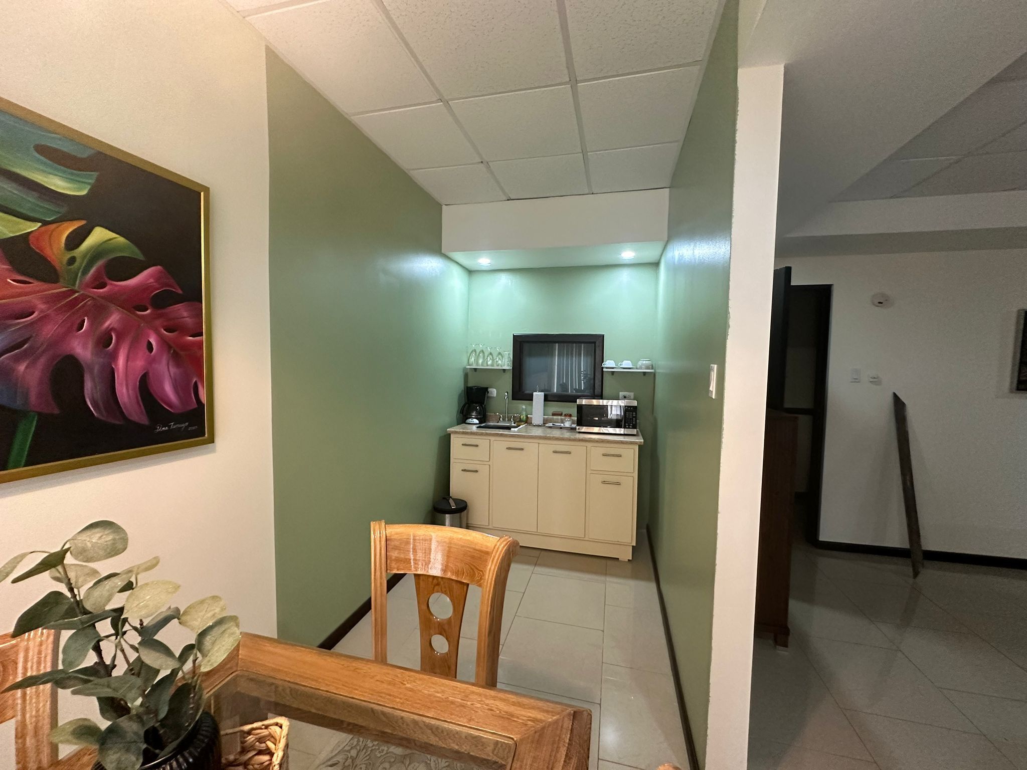 A compact kitchen with a microwave, coffee maker, and cabinets.