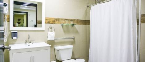 A bathroom with a toilet, sink, mirror, and shower curtain.