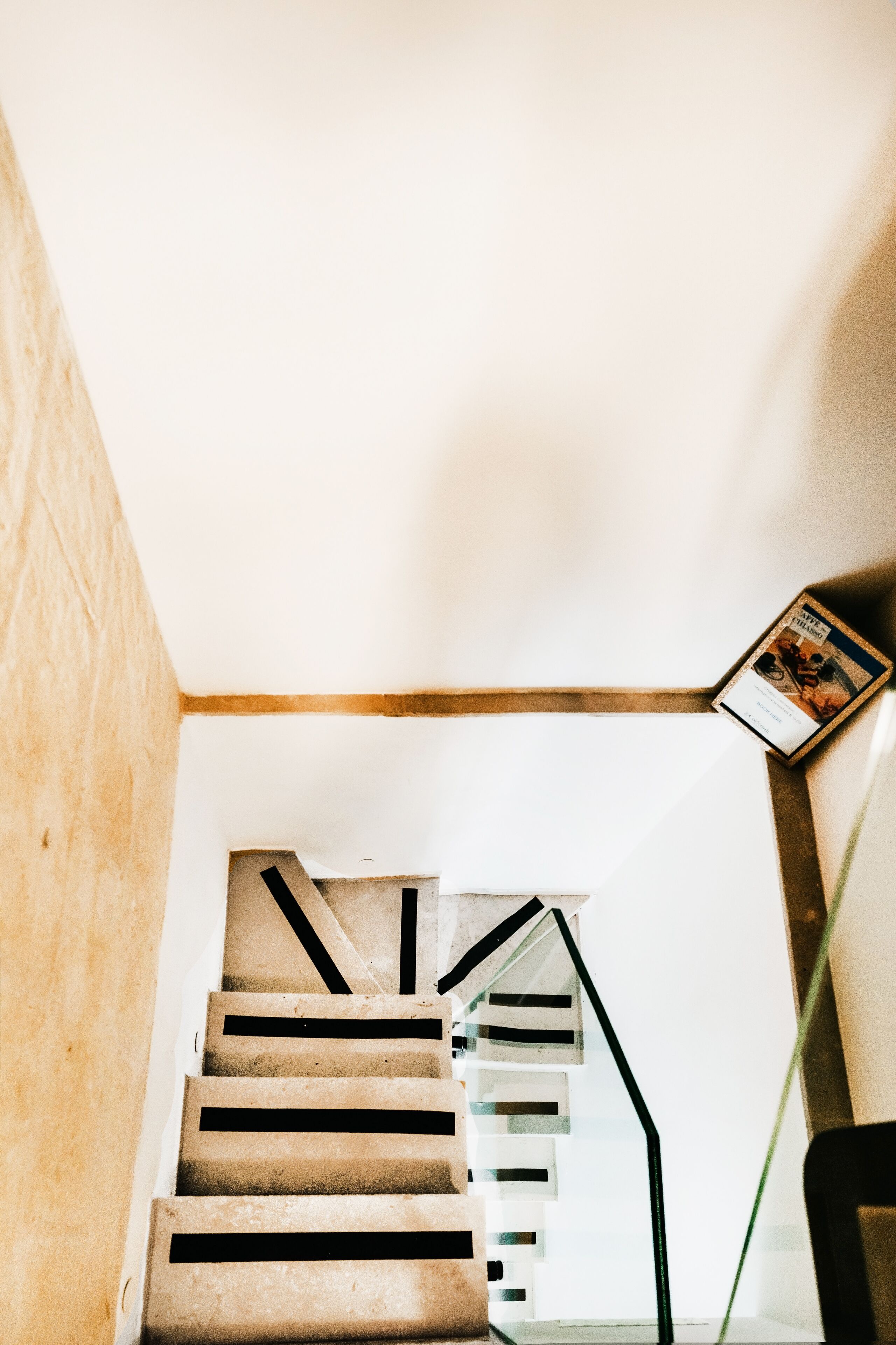 Una escalera con barandilla de madera y balaustrada de vidrio.