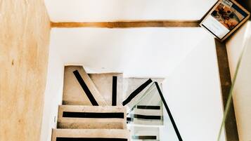 Una escalera con barandilla de madera y balaustrada de vidrio.