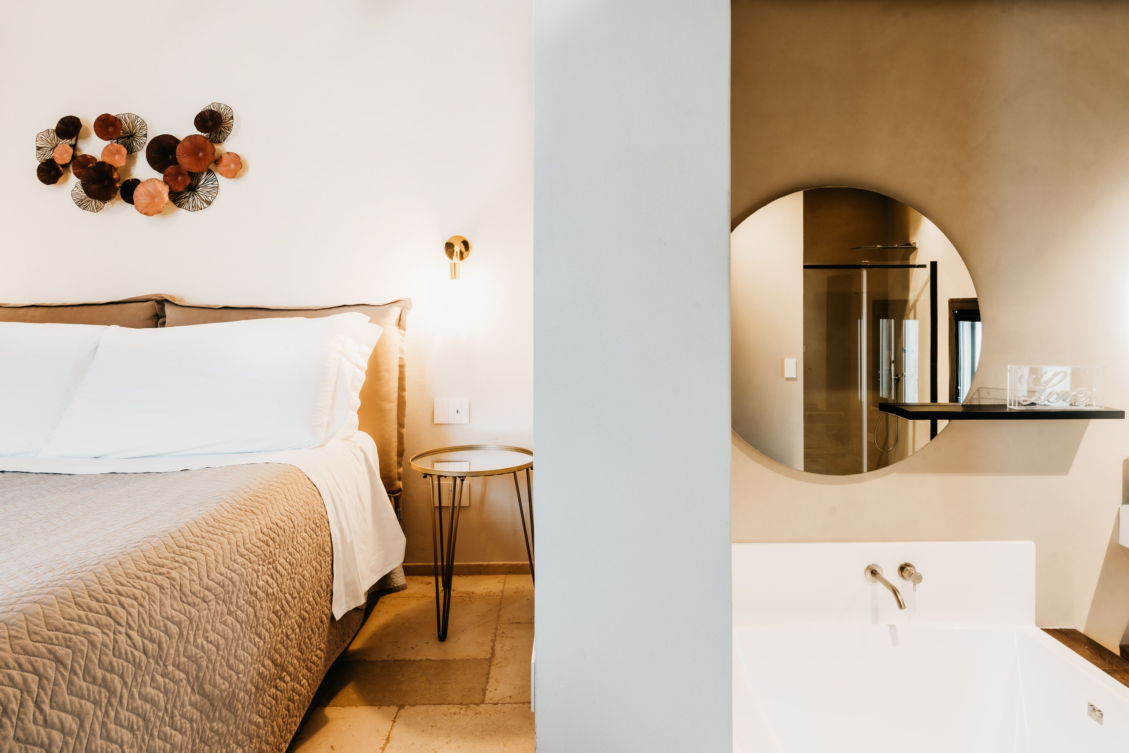 A bedroom with a bed, bedside table, and wall decor.