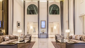 A spacious lobby with two sofas, a coffee table, and a decorative console table. - SN Plus Hotel - SHA Plus (Pattaya)
