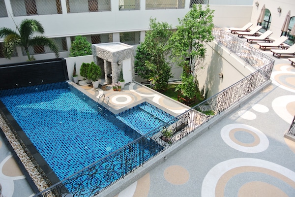 Una piscina al aire libre, sillones reclinables de piscina