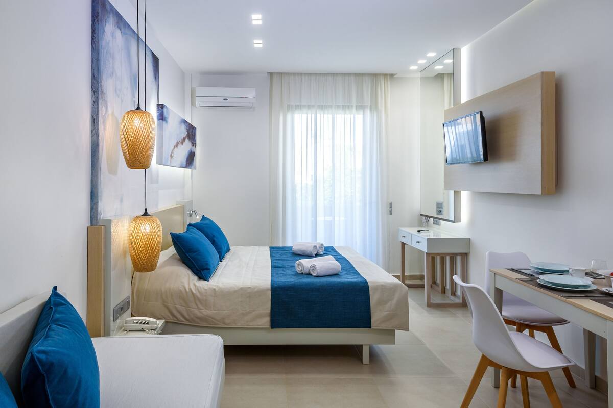 Ein modernes Hotelzimmer mit Bett, Nachttisch, Schreibtisch und Stuhl.