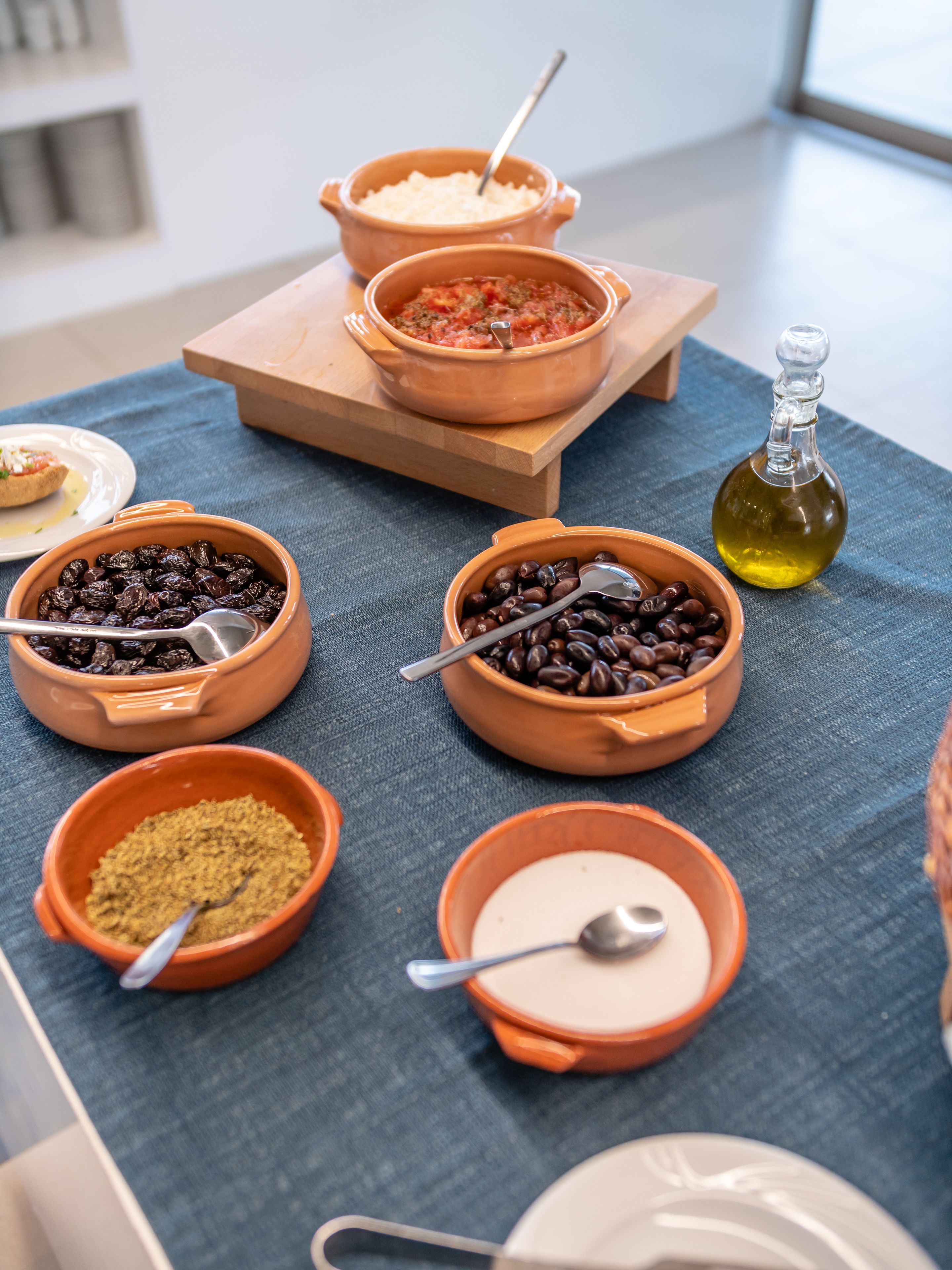 A table with various food items and a bottle of oil.