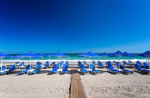 Una playa cerca, sillas reclinables de playa, sombrillas