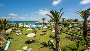 Un complexe hôtelier doté d’une piscine, de chaises longues et de palmiers.