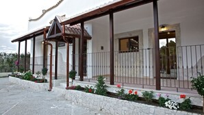 Un espacio al aire libre cubierto con escalones de piedra, una pérgola de madera y una barandilla de metal.