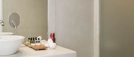 A modern bathroom with a white sink, mirror, and storage cabinet.