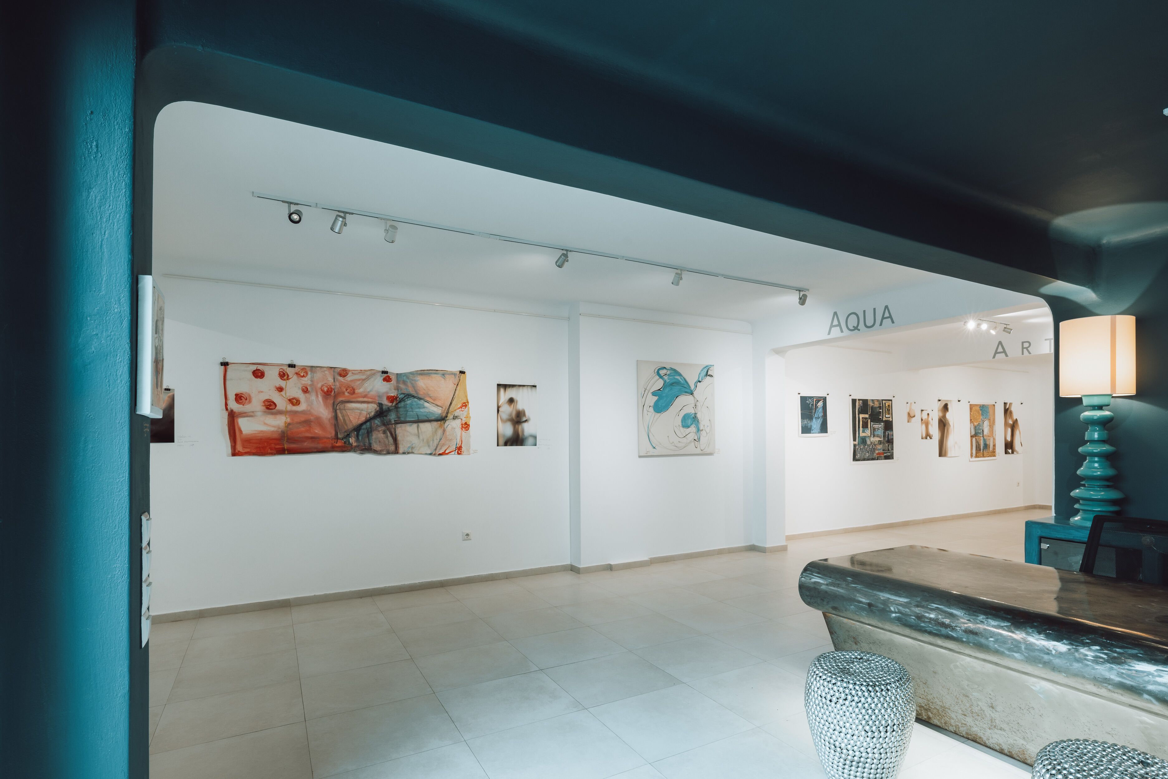 Una galería de arte con paredes blancas y suelo de baldosas.