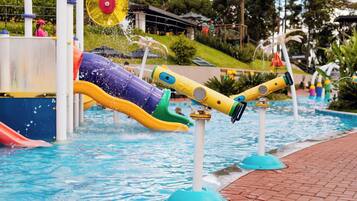 Un espace de jeux aquatiques avec des toboggans et des jets d’eau.