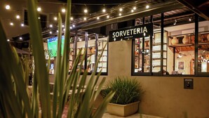 Una fachada con un letrero que dice 'SORVETERIA ICE CREAM FALLORES' y una vitrina con varios productos.