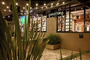A storefront with a sign reading 'SORVETERIA ICE CREAM FALLORES' and a display of various items. - Hotel Monreale Resort (Poços de Caldas)