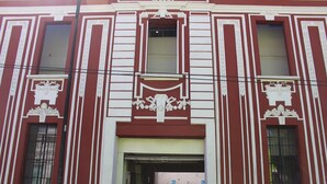 A building with a symmetrical facade, featuring vertical and horizontal lines, decorative elements, and a central entrance. - Hotel Casa de Oración San José (Puebla)