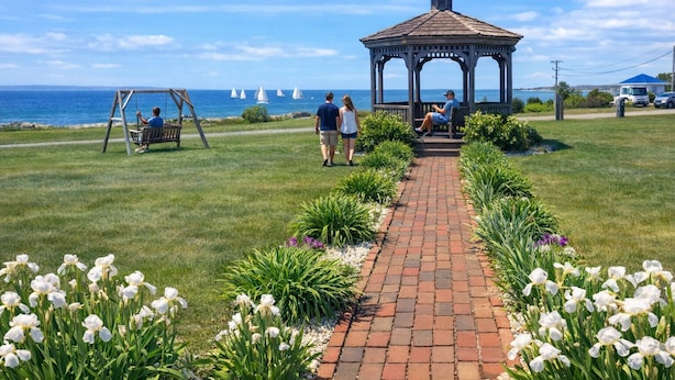 A gazebo, a swing set, and a pathway lined with flowers leading to the sea. - Mariner's Point Resort (Falmouth)