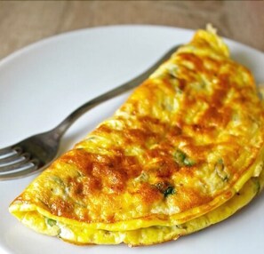 Una tortilla francesa doblada sobre un plato blanco.