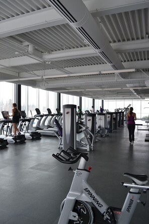 Un gimnasio con cintas de correr, bicicletas estáticas y máquinas de pesas.