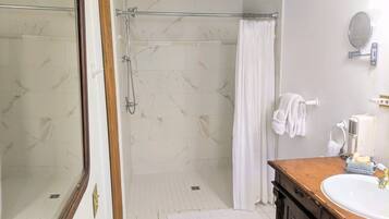 A bathroom with a shower, a sink, and a mirror.