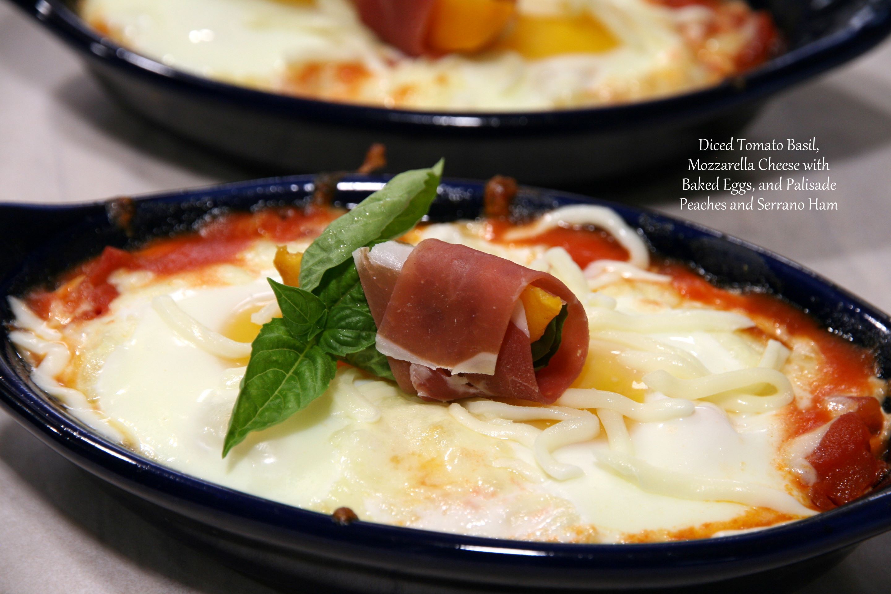 A dish with diced tomato basil, mozzarella cheese, baked eggs, and prosciutto.