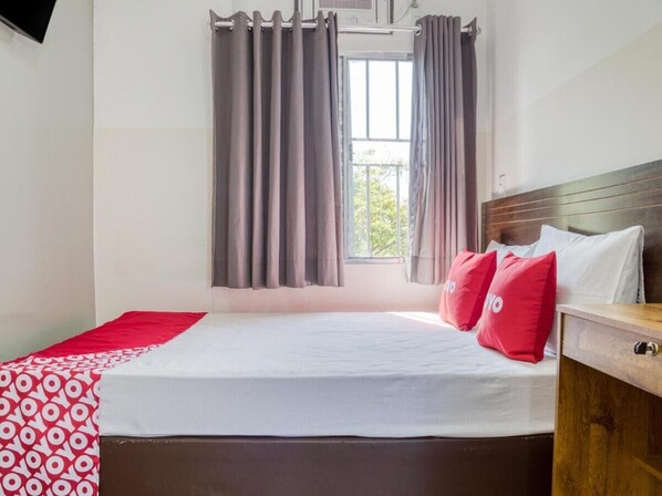 A bedroom with a bed, curtains, a window, and a wooden headboard. - Hotel Paulistano (São Paulo)