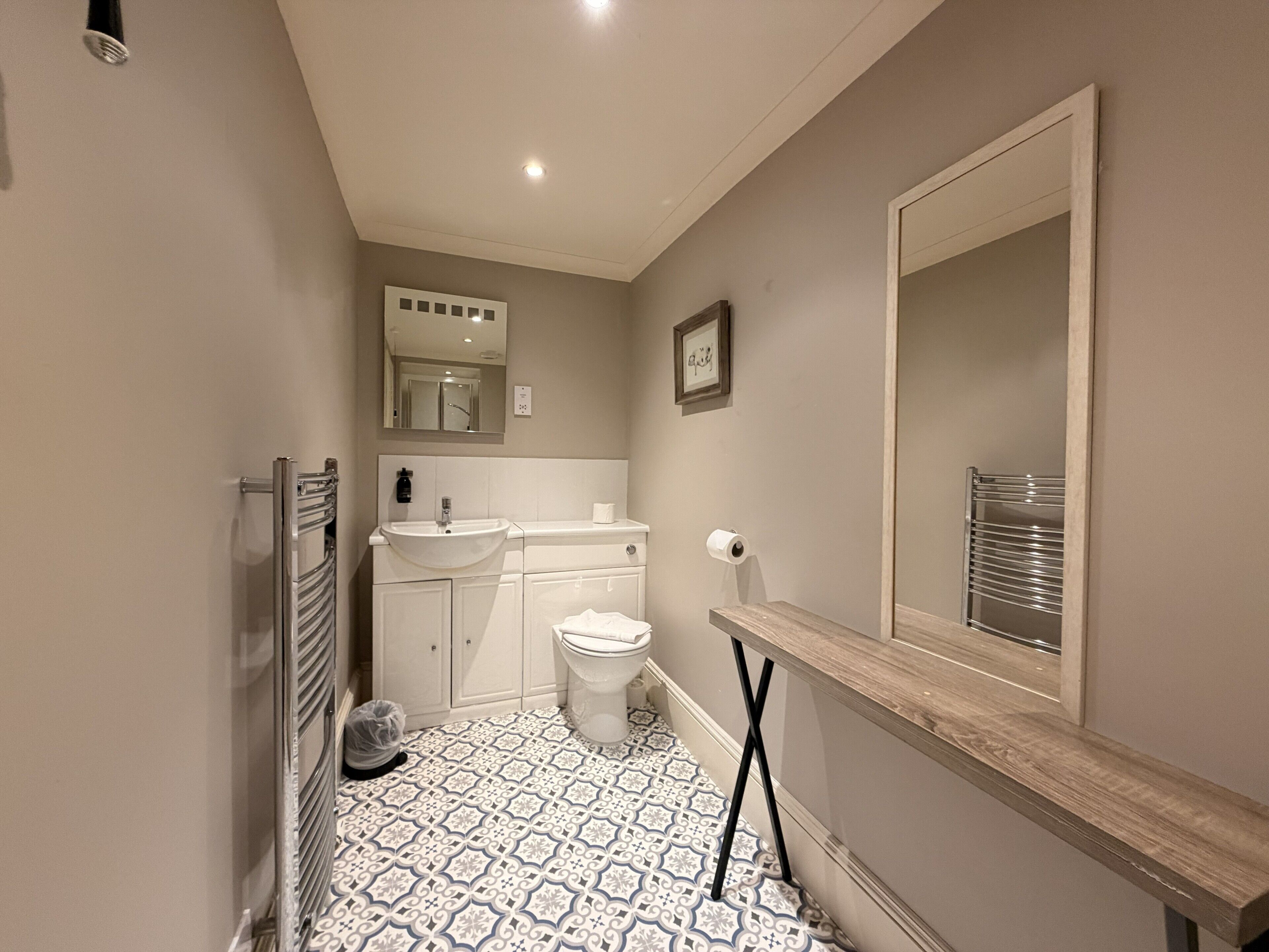 A bathroom with a toilet, sink, and mirror.