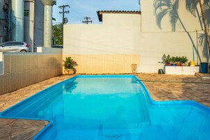 Una piscina al aire libre, tumbonas