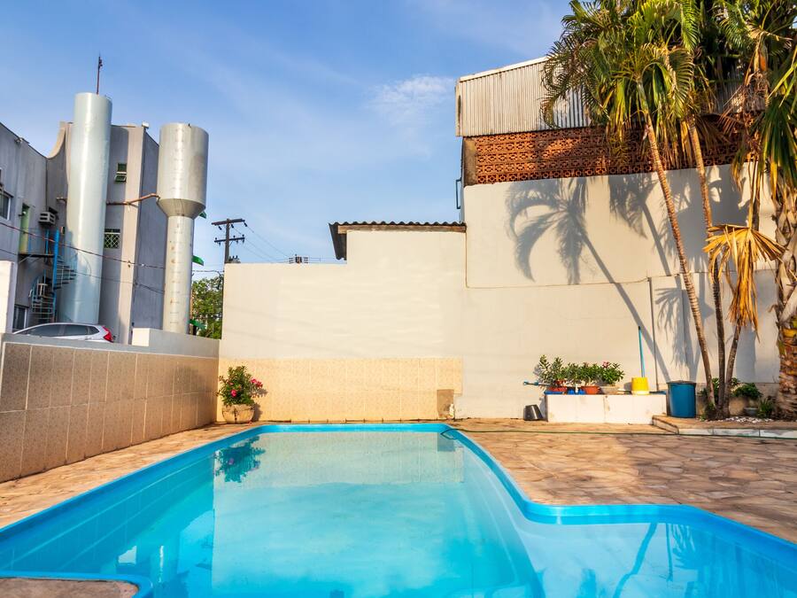 Una piscina al aire libre, sillones reclinables de piscina
