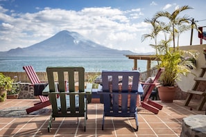 A patio with two chairs facing a mountain view. - La Iguana Perdida - Hostel (Santa Cruz La Laguna)