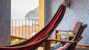 Ein Hängesessel mit Blick auf Strand und Meer.