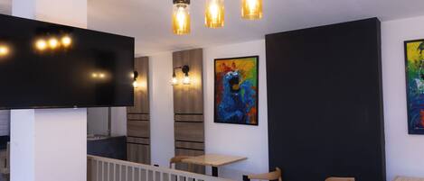 A modern interior with a flat-screen TV, wooden furniture, and abstract art on the walls.