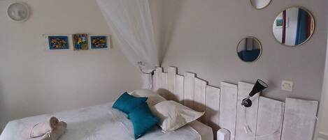 A bed with a canopy, a bedside table, and wall-mounted mirrors.