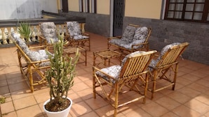 A patio area with wicker furniture and potted plants. - Pousada Sognares (Guarulhos)